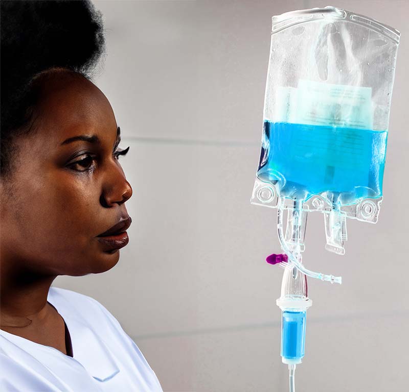 IV Therapy Bermuda with an African Woman Looking at IV Bag